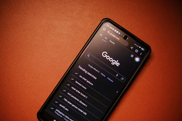 A smartphone displaying Google Search trends on a table at night. Trend-tracking platforms compared: seven habits and how seven tools score